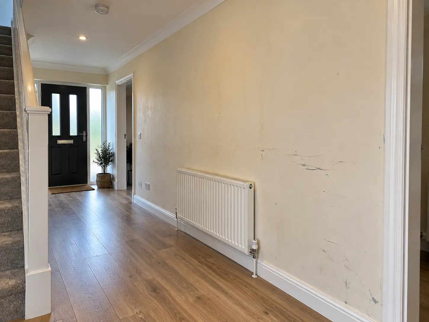 Hallway with a worn painted wall before Venetian plaster